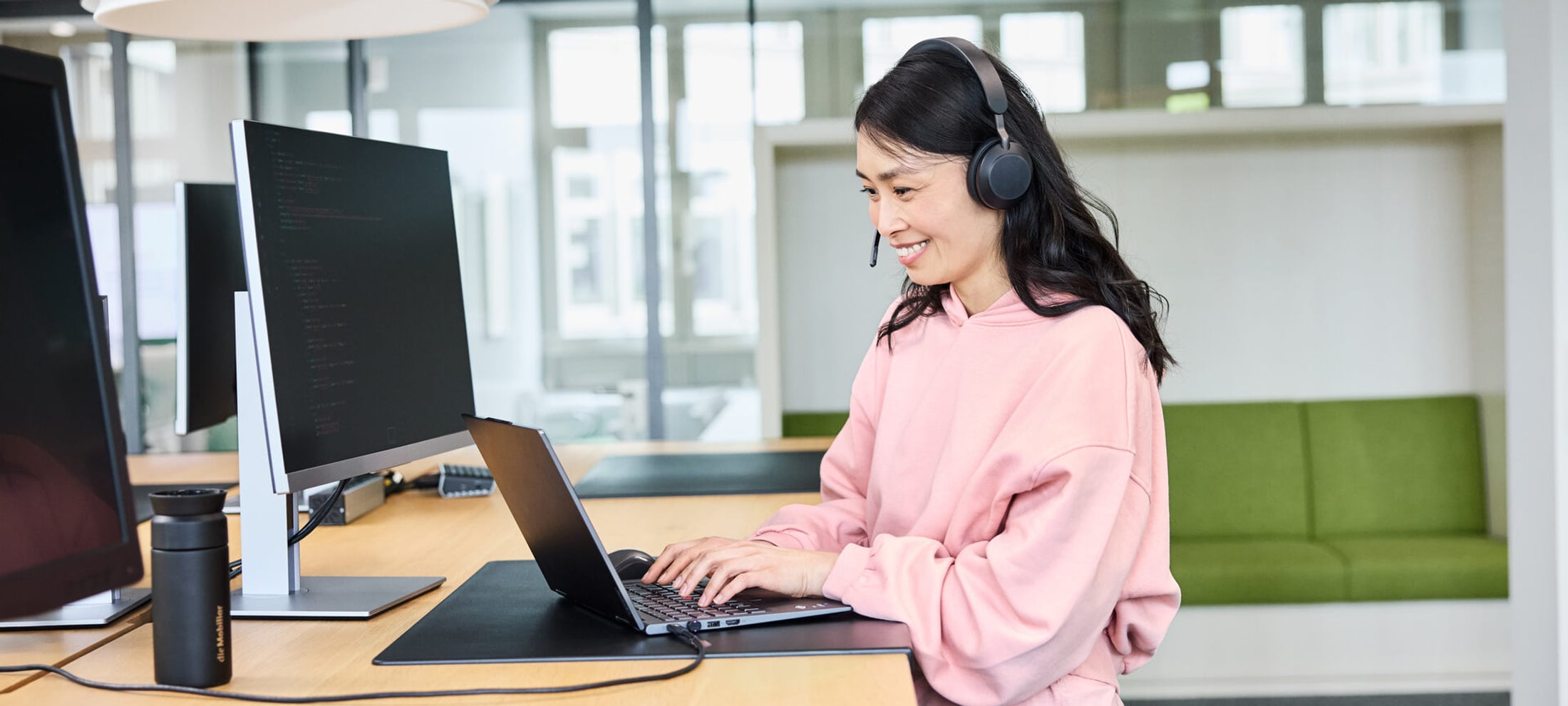 Frau mit Kopfhörer am Laptop 