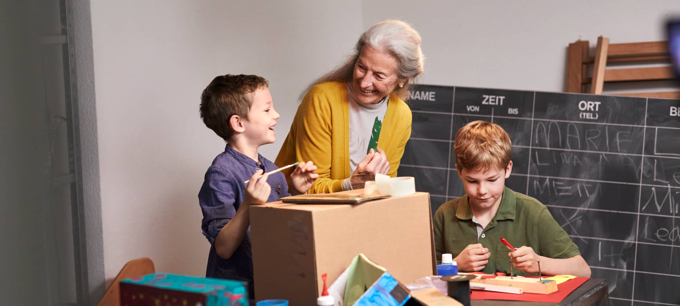 Ältere Frau mit Kinder am basteln