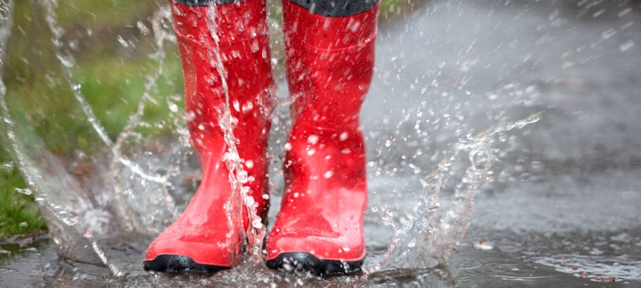 Des bottes rouges dans une flaque d’eau