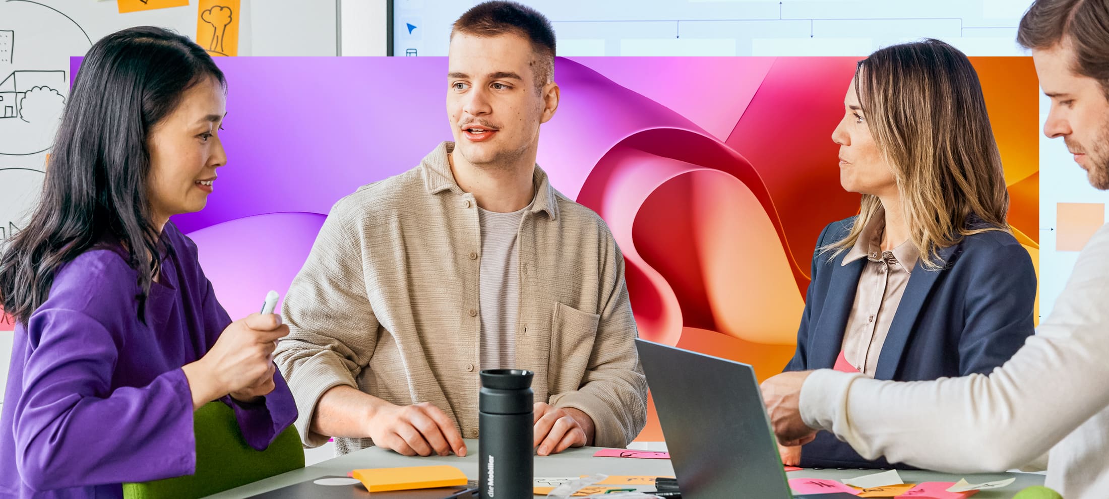 Junge Mitarbeitende im Teamwork mit Laptop und Whiteboard
