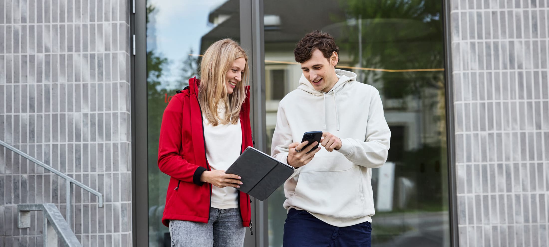 Zwei junge Personen vor einem Eingang einer Mobiliar Generalagentur