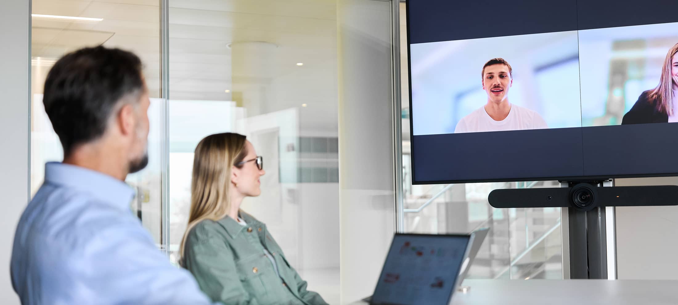 Mitarbeitende haben ein Meeting vor Ort und Remote