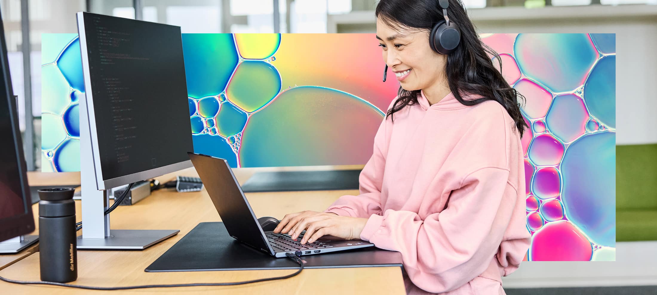 Ein Frau an einem hohen Holztisch am Notebook