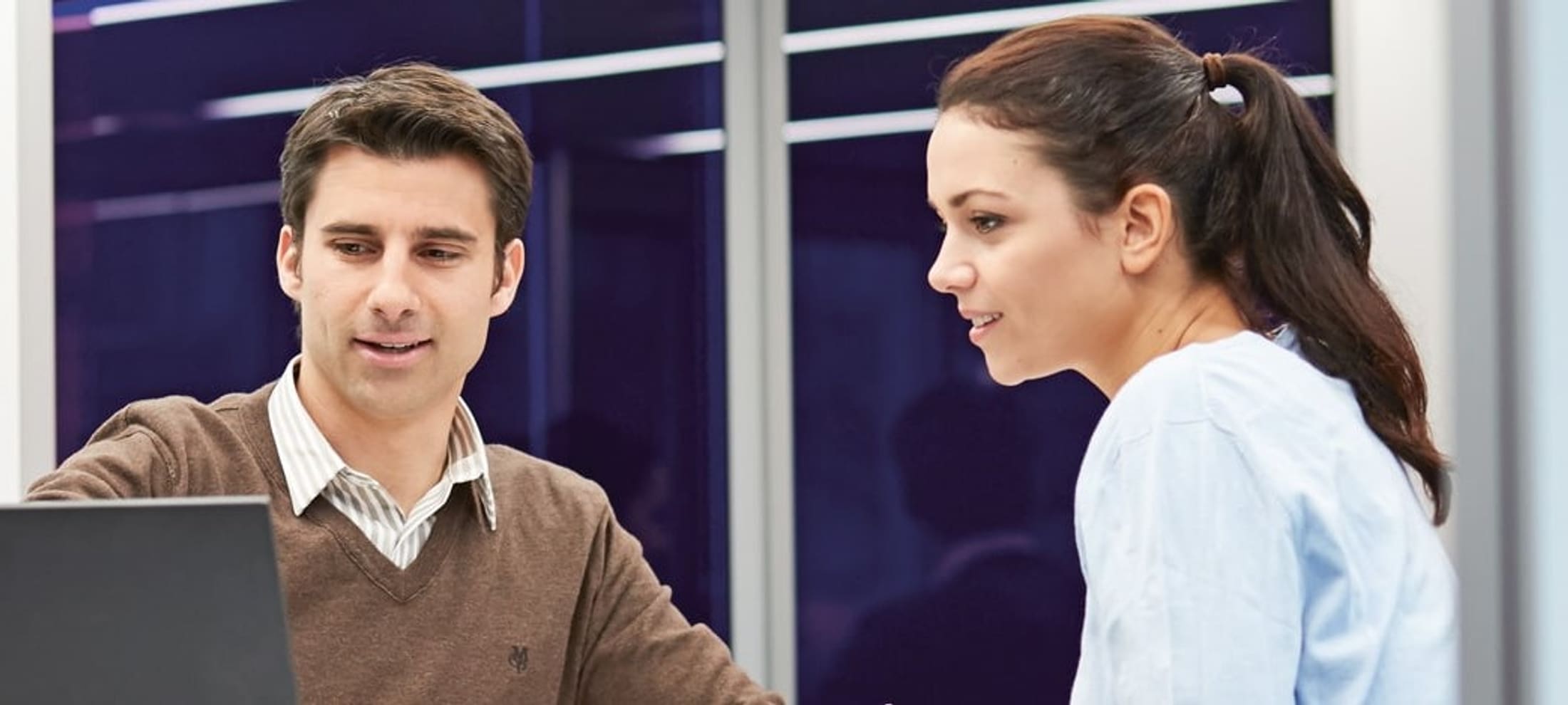 Un homme et une femme regardent un écran.