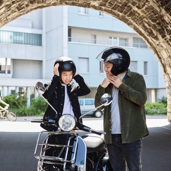 Deux hommes se tiennent dans un tunnel avec un scooter et mettent un casque