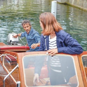 Un couple part en excursion sur un lac à bord d’un bateau à moteur