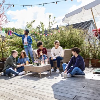 Jugendliche sitzen auf einer Terrasse