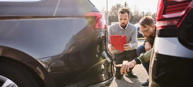 Zwei Männer schauen ein Auto genau an.