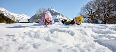 Zwei Kinder im Schnee am Spielen