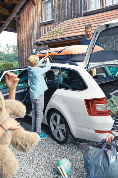 Une famille charge la voiture avec ses bagages pour les vacances.