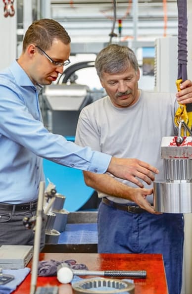 Due uomini davanti a un impianto tecnico di comando
