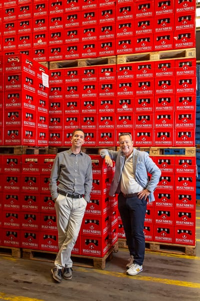 Zwei Männer vor einem Lager der Rugenbräu