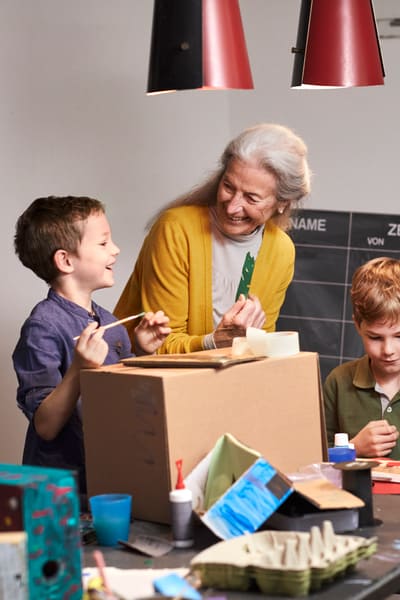 Ältere Frau mit Kinder am basteln