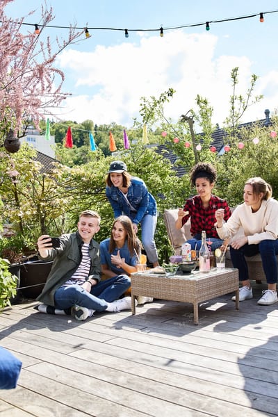 Sei giovani festeggiano sulla terrazza la nuova casa condivisa 