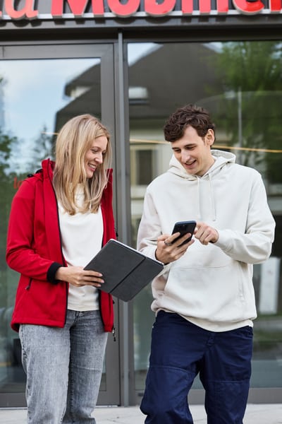Frau und Mann besprechen an Stehtisch etwas und blicken gemeinsam in einen Laptopbildschirm