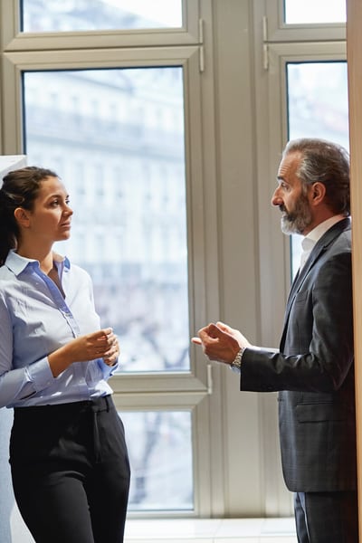 Un homme et une femme se retrouvent au bureau pour discuter d’affaires.