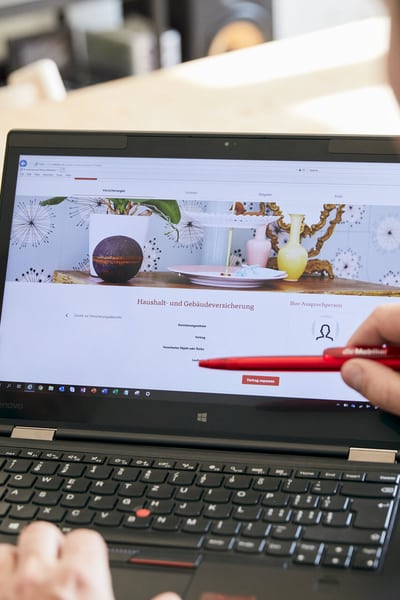 Un uomo indica lo schermo di un portatile.