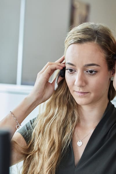 La donna si mette l’auricolare davanti al computer