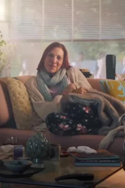 Clip pubblicitario della Mobiliare donna seduta sul divano in soggiorno