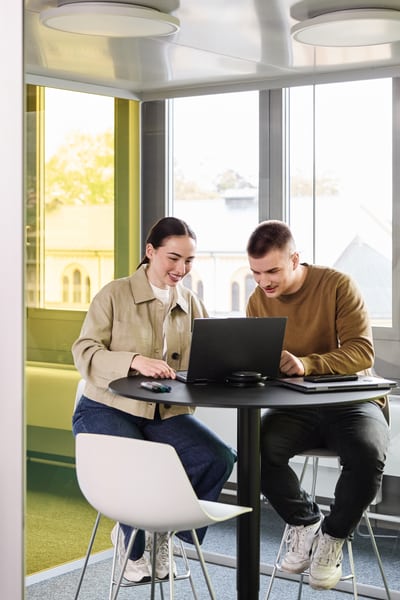 Mitarbeitende schauen gemeinsam auf einen Laptop 