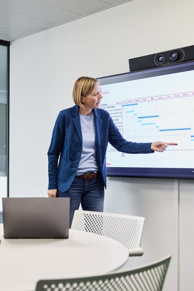 Un uomo sta di fronte a un muro con molti schermi e parla