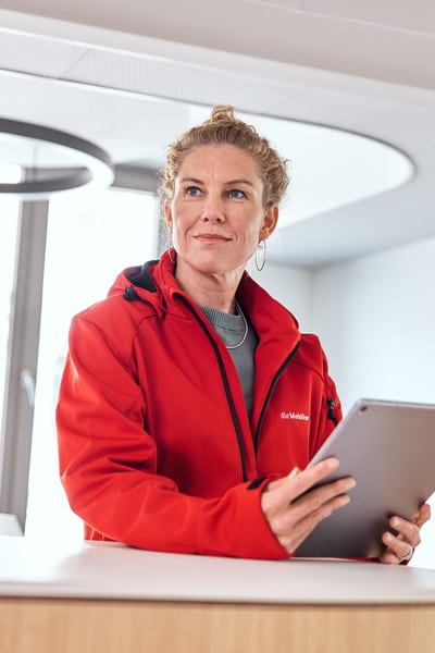Mitarbeiterin ist am Stehpult mit Tablet in der Hand