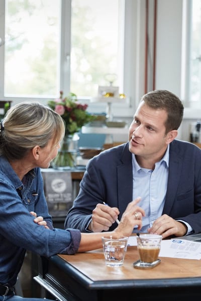 Eine Frau und ein Mann besprechen etwas am Tisch