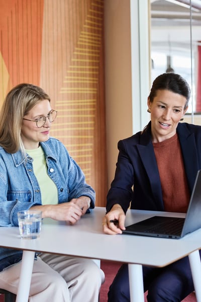 Due donne guardano un computer portatile.