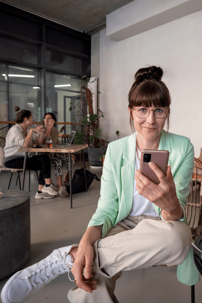 Junger Frau im Kaffee schaut auf ihr Smartphone