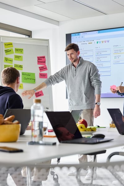 Mitarbeitende beim Teamwork mit Post-its und Screen