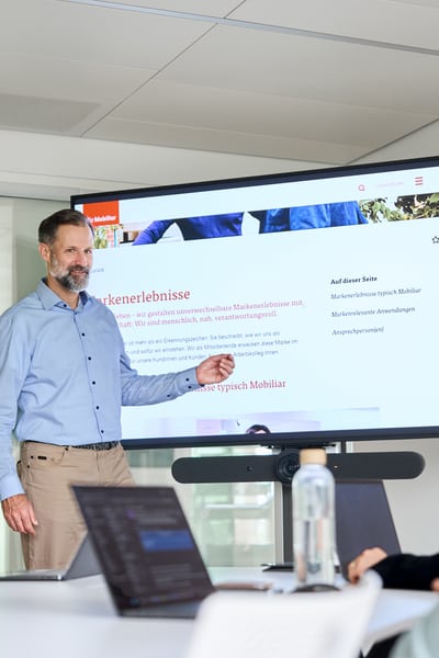 Il gruppo discute di qualcosa in piedi guardando un laptop