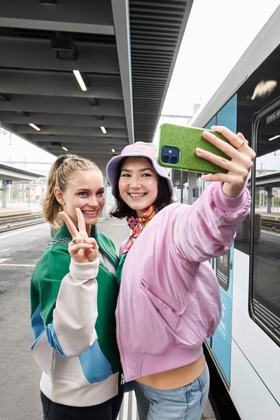 Des jeunes femmes prennent un selfie à la gare.