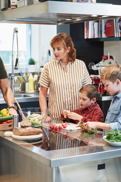Mamma, papà e i due figli sono in cucina a preparare la cena. 