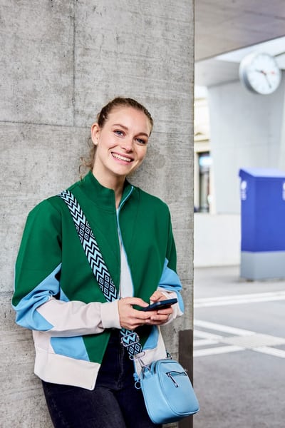 Une jeune femme s’appuie contre le mur en attendant le train.
