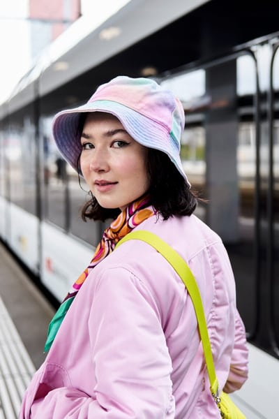 Une jeune femme pose devant le train qui entre.