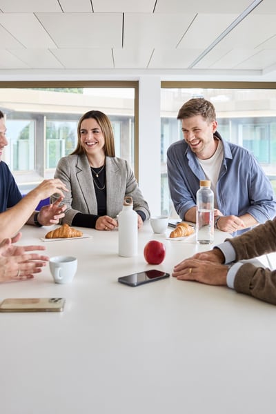 Mitarbeitende sind bei Kaffee und Gipfeli im Austausch 