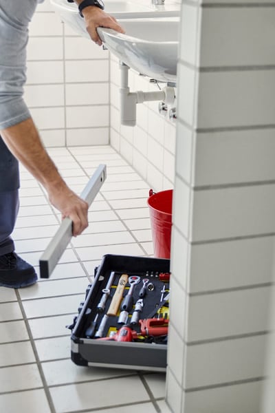Ein Handwerker arbeitet an in einem Badzimmer.