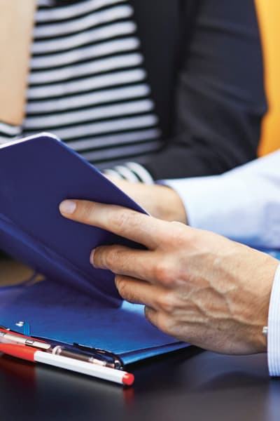 L’uomo tiene in mano il taccuino e spiega qualcosa