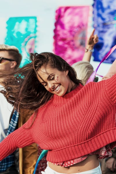 Junge Frau mit rotem Pullover am Festival
