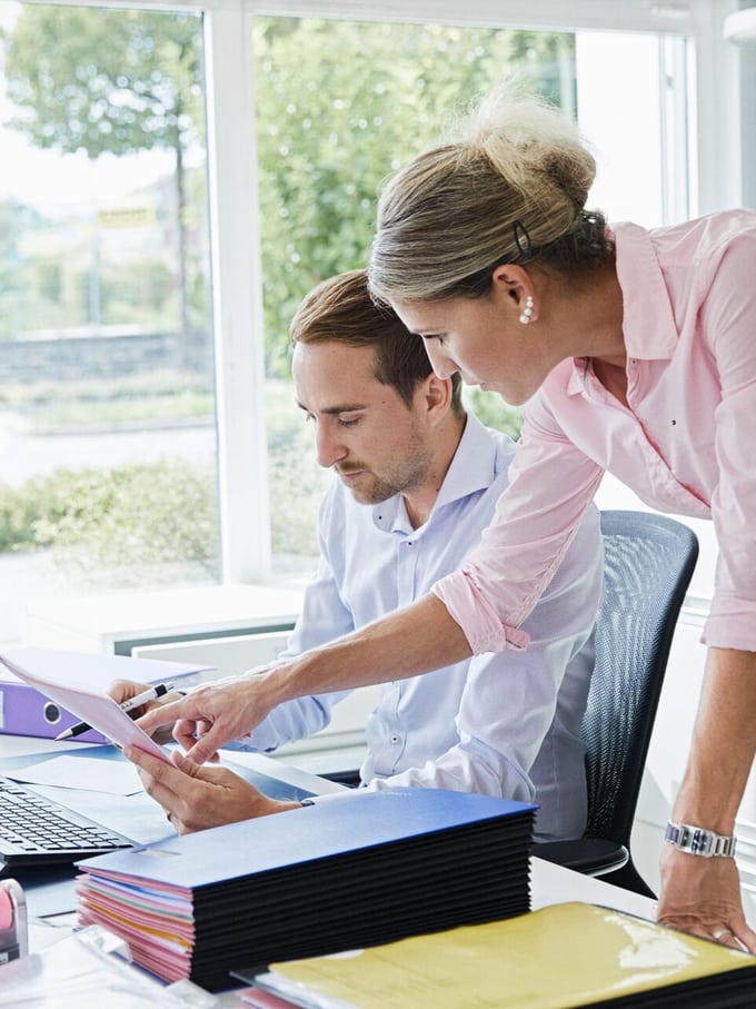 Un homme et une femme discutent à un bureau.