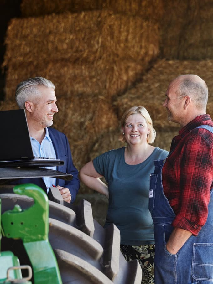 Il contadino discute con un consulente nella stalla.