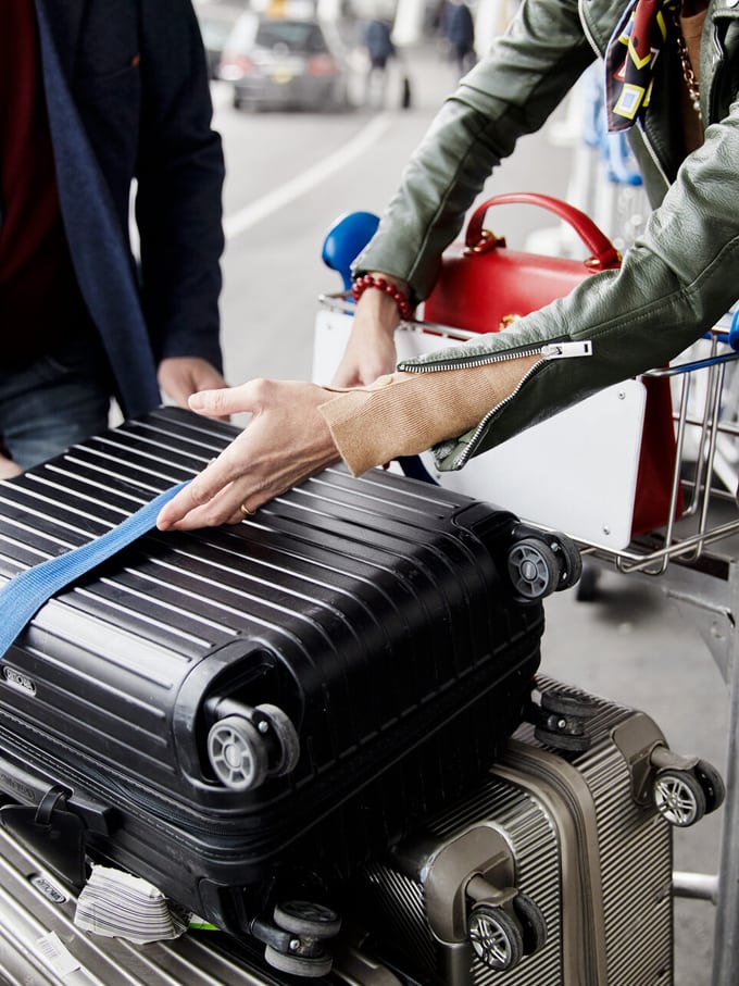 Rollkoffer auf Gepäckwagen am Flughafen.