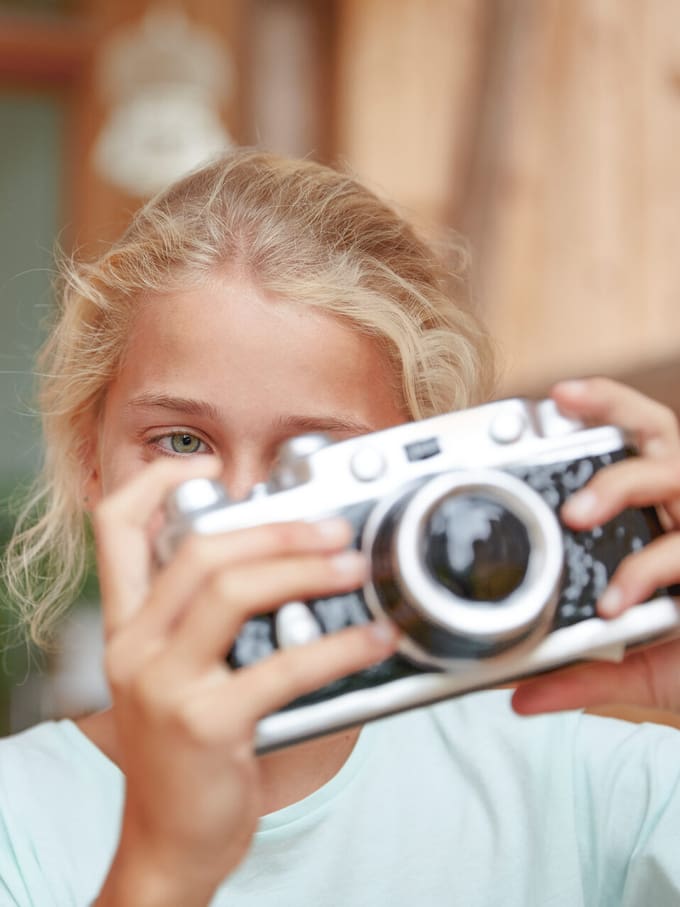 Una ragazza con una macchina fotografica in mano