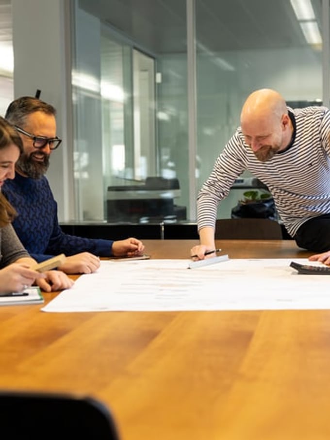 Plusieurs personnes discutent d’un plan de construction.