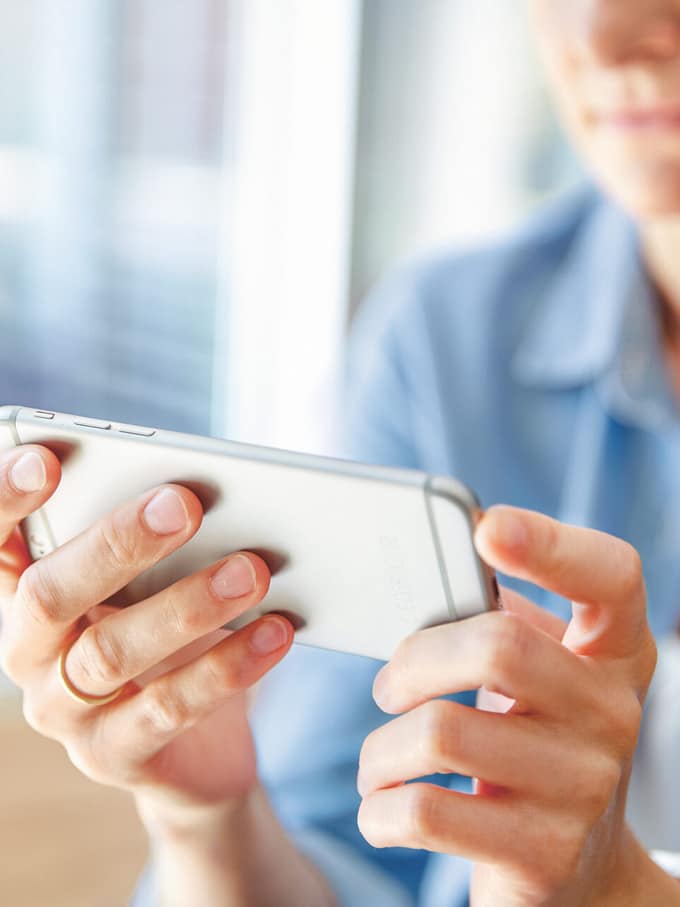 Frau bedient silbernes Smartphone.