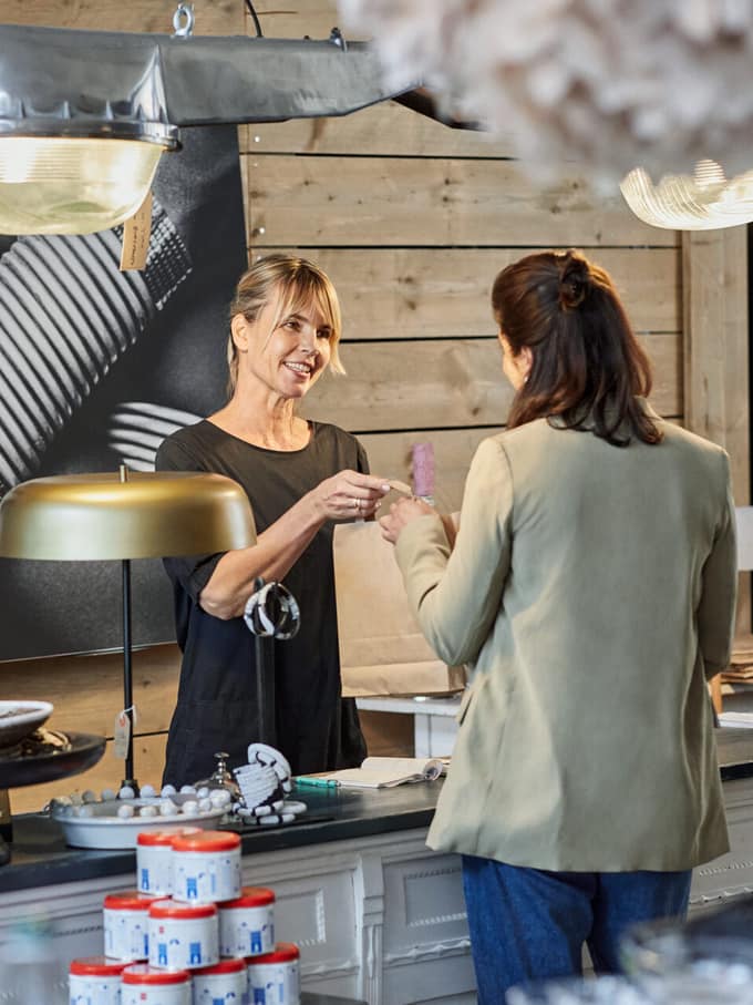 Zwei Frauen unterhalten sich an einer Ladentheke.