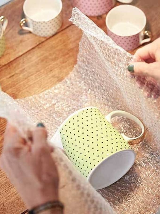 Eine Frau packt eine Tasse ein