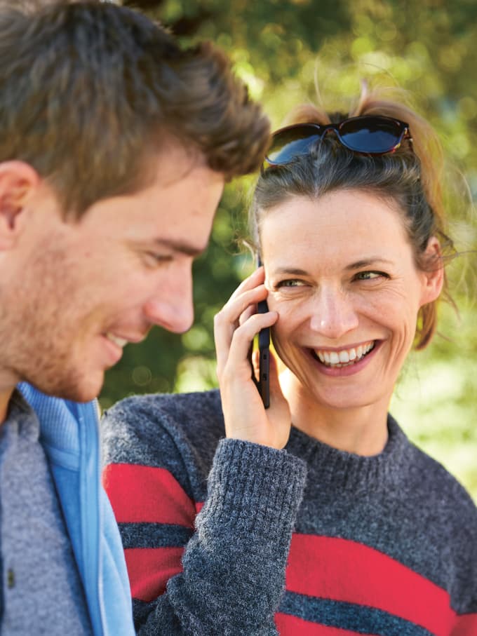 Zwei Personen im Park und die Frau telefoniert.