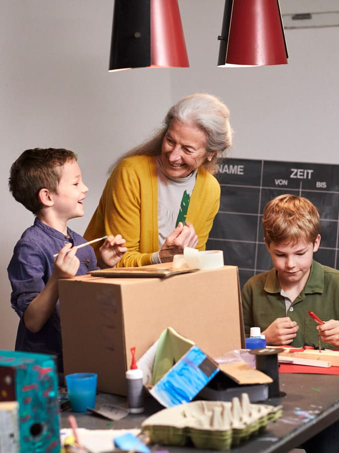 Une dame âgée et deux enfants bricolent ensemble