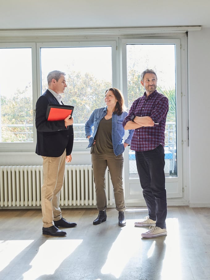 Paar im Wohnzimmer bei einer Hausbesichtigung, Projekt Hauskauf 